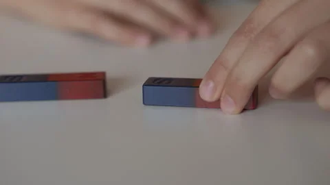 School Science Educational Experiment With Magnets. Child Hands Moves Two M.. Stock Footage 283531359
