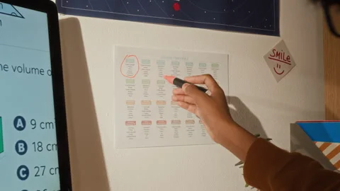 School Student Marking Important Study Days on Monthly Lesson Timetable Stock Footage 334968978