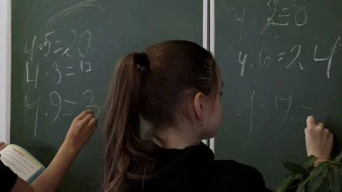 A school student writing mathematical equations on a chalkboard in a classr.. Stock Footage 339862375