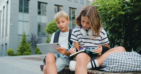 School students friends outdoors using digital tablet computer . Kids sitting on Stock Footage 248618506