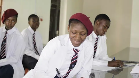 School students learning ,writing and listening to teacher in the classroom Видео 252325917