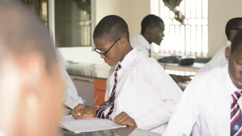 School students learning ,writing and listening to teacher in the classroom Vidéo 252326850