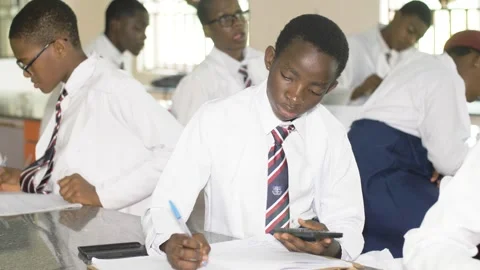 School students learning ,writing and listening to teacher in the classroom Stockbeeldmateriaal 252327394