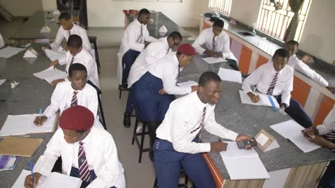 School students learning ,writing and listening to teacher in the classroom Vidéo 252328980