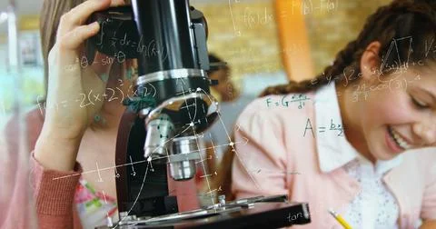 In school, students using microscope and laughing, enjoying science class Illustrazione stock