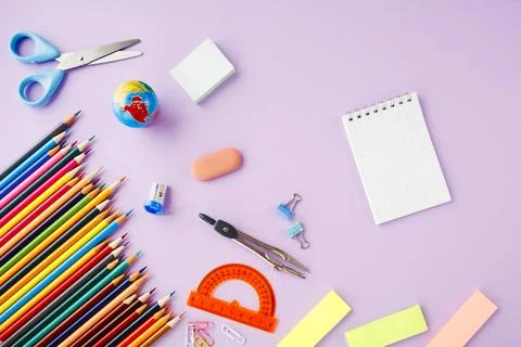 School supplies and open notebook on violet background, top view, back to sch Stock Photos