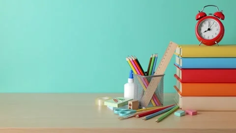 School supplies, a book stack, and an alarm clock are on the desk. Stock Footage 249606529
