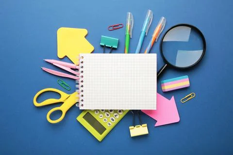 School supplies with notebook on blue background. Back to school. Flat lay. Stock Photos
