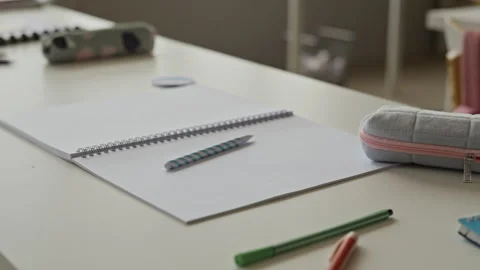 School Supplies with Open Notebook Lying on Desk in Classroom Stock Footage 340547902