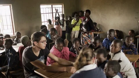 School teacher &amp; charity workers in class with children from African community Stock Footage 77410289