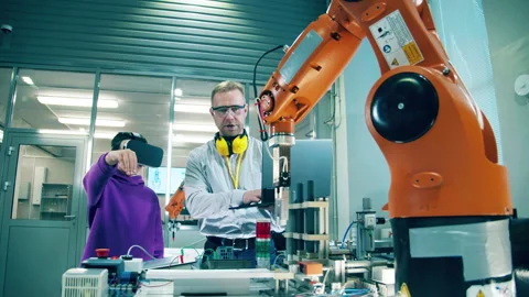 School teacher helps a boy to operate a bionic arm using VR technology Stock Footage 240340763