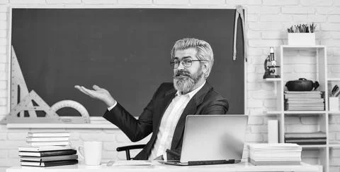 School teacher programming laptop. Learn programming language. Handsome man use Foto stock