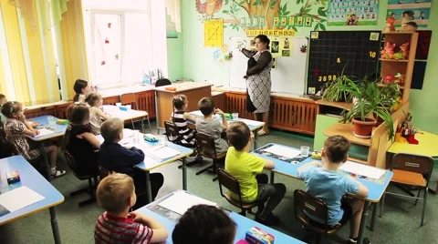 A school teacher writes on the whiteboard Stock Footage 53752980