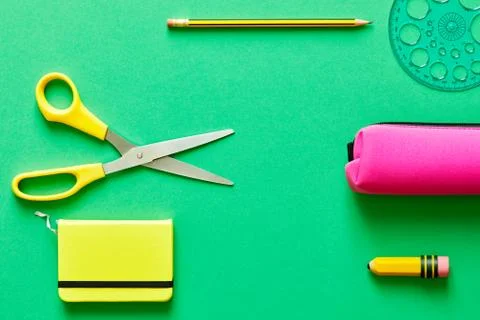 School tools over a blue flatlay in green from above Stock Photos