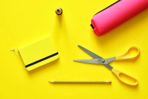 School tools over a yellow flatlay in blue from above Stock Photos