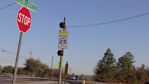 A School zone speed limit flashing yellow sign and lights with traffic and bl Stock Footage 149224373