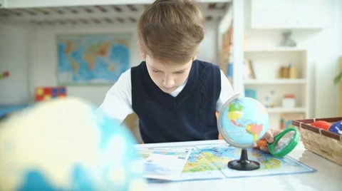 Schoolboy and geographical atlas. The boy student studying geography Stock Footage