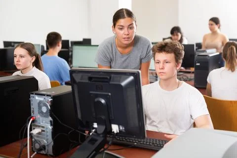 Schoolboy and teacher using PC in computer class Stockfoto's
