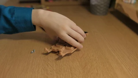 Schoolboy assembling his red model car. Used screwdriver to screw cogs Stock Footage 129401842
