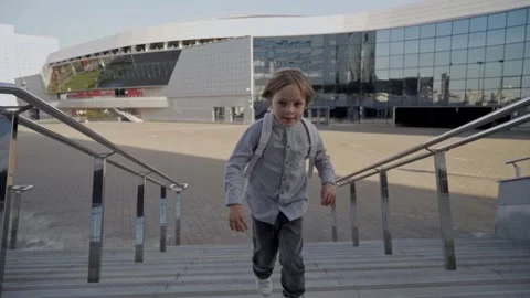 Schoolboy with backpack run upstairs to school for lessons at sunny day. Front Stock Footage 140257522