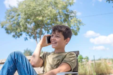 Schoolboy on bench taking break using mobile Stock Photos