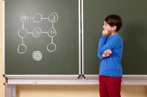 Schoolboy at blackboard with arithmetic problem Stock Photos