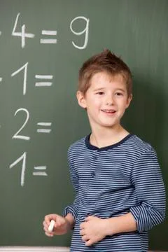 Schoolboy at blackboard with arithmetic problems 스톡 사진