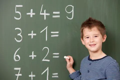Schoolboy at blackboard with arithmetic problems Stock Photos