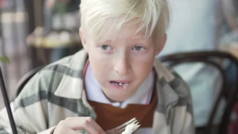 A schoolboy boy eats cheesecakes in the school canteen Video stock 224714663