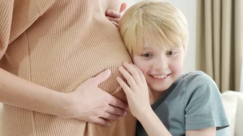 A schoolboy boy hugging mom and listening her pregnant belly Stock Footage 262293448