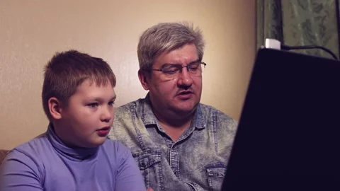 Schoolboy boy studying online from home dad helps the child. Stock Footage