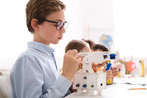 Schoolboy building and programming robot in computer coding class Foto stock