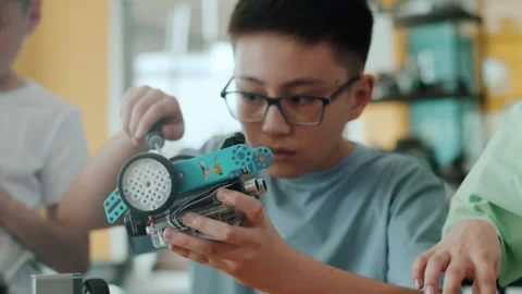 Schoolboy in a class at a robotics lesson sitting at the table and attentively Video stock 242170198