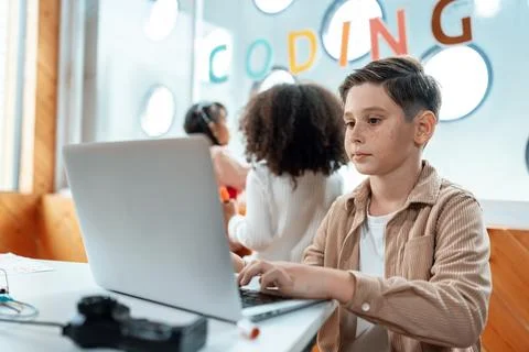 The schoolboy in classroom sitting and learn engineering with laptop. Erudition. Stock Photos