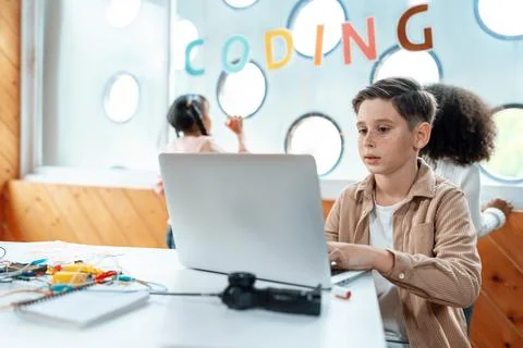 The schoolboy in classroom sitting and learn engineering with laptop. Erudition. Stockfoto's