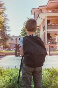 Schoolboy comes back to school. Behind shoulders at the pupil a satchel.Back  Stock Photos