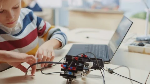 Schoolboy Connects Cables to Robot, Uses Laptop to Program Software Stock Footage 119561267