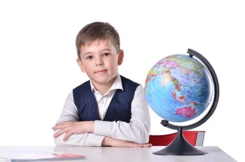 Schoolboy at the desk with a globe on it Stock Photos