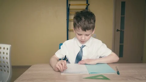 Schoolboy does homework, the wrench in his hands is a pen. Stock Footage 105099113