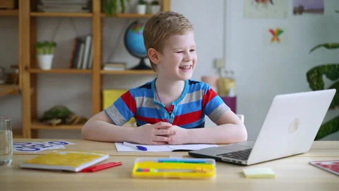 Schoolboy doing homework and having fun in front of laptop screen at home room Stock Footage 155269348