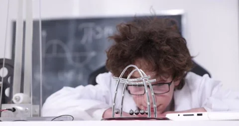 Schoolboy experimenting in physics class. Young student doing physics experiment Stock Footage 172441623
