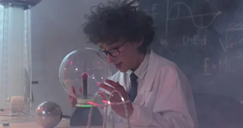 Schoolboy experimenting in physics class. Young student doing physics experiment Stock Footage 172442464