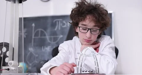Schoolboy experimenting in physics class. Young student doing physics experiment Stock Footage 173393678