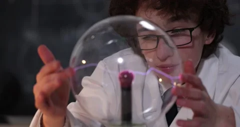 Schoolboy experimenting in physics class. Young student doing physics experiment Stock Footage 173394921