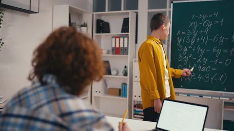Schoolboy explaining the solution to math problem in front of class, high school Stock Footage 250334081