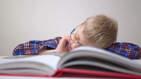 Schoolboy fell asleep while reading book boy with glasses. tired of lessons Back Stock Footage 158257635