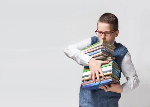 Schoolboy in glasses with stack of books Stock Photos