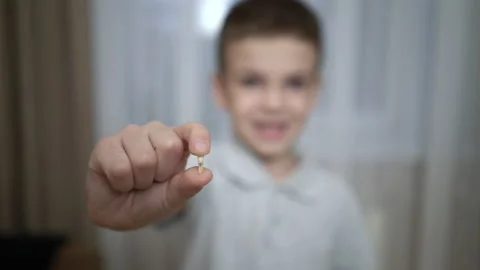 Schoolboy holds the first fallen tooth in his hands. The boy shows a fallen milk Stock Footage 219497378