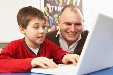 Schoolboy In IT Class Using Computer With Teacher Stock Photos