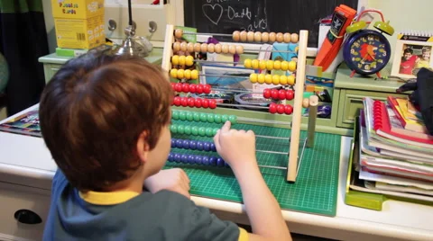 Schoolboy kid doing homework and learning maths counting with abacus at desk Stock Footage 43115691